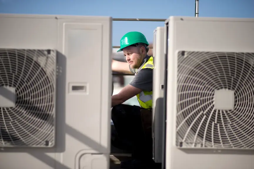 Image of worker in between heat pumps