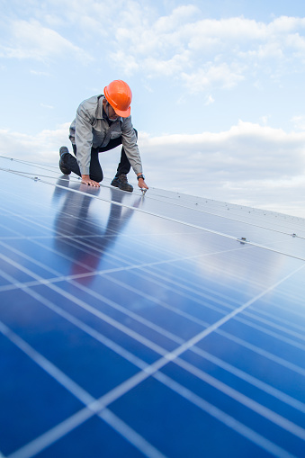 Image of person installing solar panels