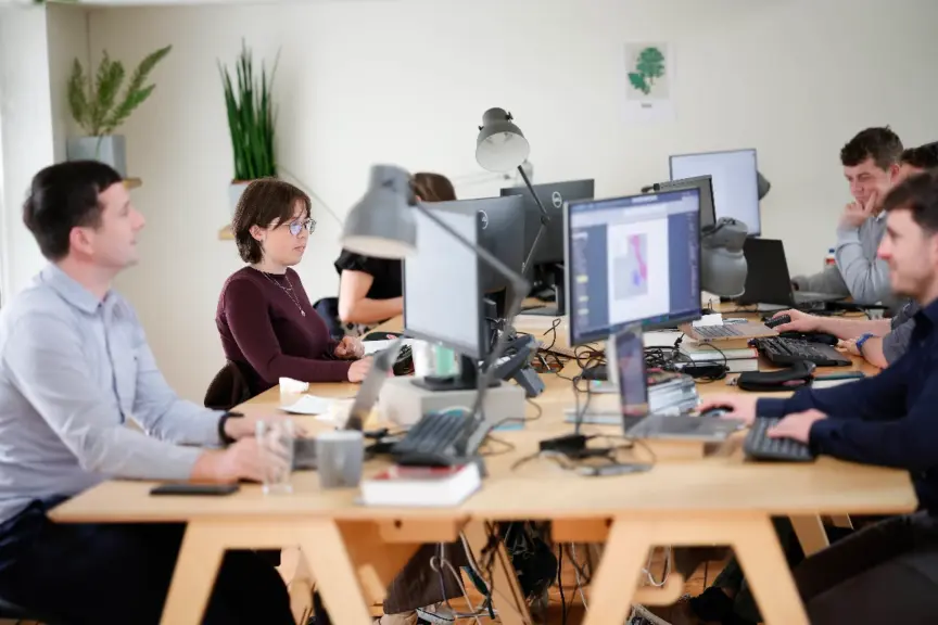 Codema staff members sit in a bright office working at computers