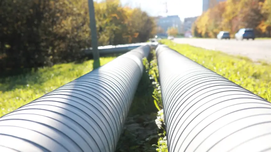 Photo of district heating pipes running along the grass beside a road