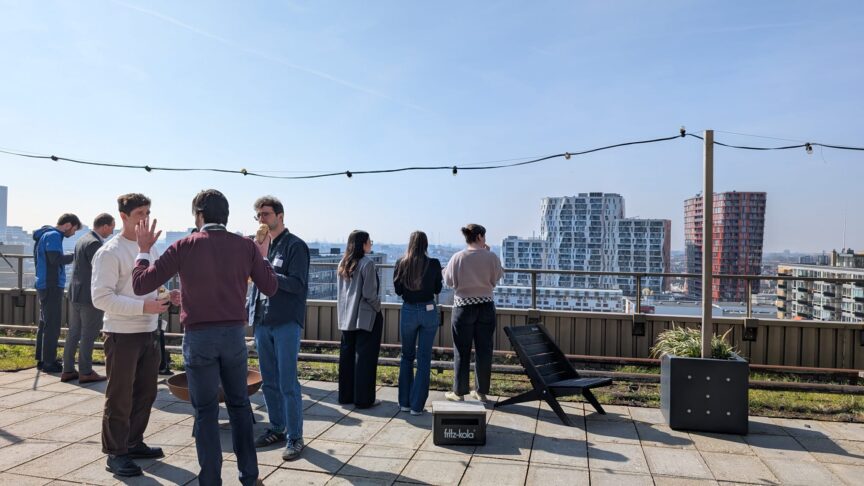 Image of a group of people standing on a rooftop with high-rise buildings in the background